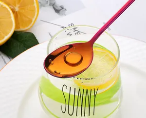 Vue détaillée d'une cuillère en acier inoxydable arc-en-ciel sur un verre de citronnade