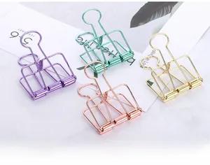 Macro shot of colorful hollow metal binder clips in purple, rose gold, and cyan tones