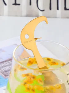 Detail eines goldenen Passionsfruchtöffners aus 304 Edelstahl am Rand eines Glases