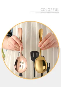 Detail of rose gold slotted spoon and gold solid serving spoon with mirror finish