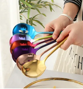 Macro detail of hand-held colorful stainless steel serving spoon and slotted spoon set