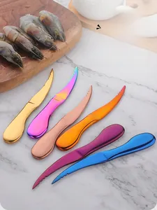 Close-up of colorful stainless steel shrimp deveiners with serrated blades on marble surface