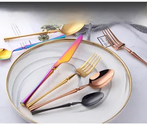 Macro view of mirror-polished gold stainless steel cutlery set with sleek curved handles