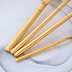 Minimalist matte gold stainless steel cutlery set with elegant V-shaped handles on marble