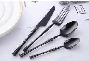 Close-up of modern black 304 stainless steel cutlery set on elegant marble background