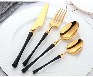 Modern gold and black 304 stainless steel four-piece cutlery set displayed on a plate