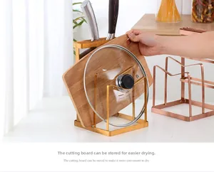 Detail of rose gold kitchen rack showing a hand placing a cutting board for easy drying