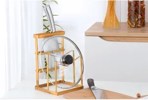 Detail of gold stainless steel kitchen organizer holding a knife and a glass pot lid