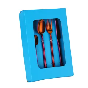 Gros plan d'un set de 4 couverts arc-en-ciel dans une boîte cadeau bleue à fenêtre