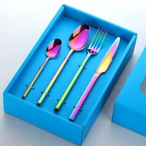 Détail macro du service de couverts arc-en-ciel en acier dans un coffret bleu