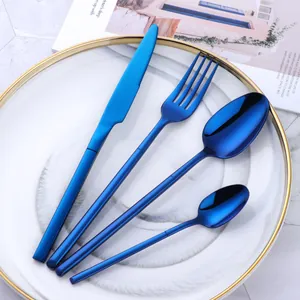 Modern 4-piece stainless steel cutlery set with vibrant blue finish on a ceramic plate