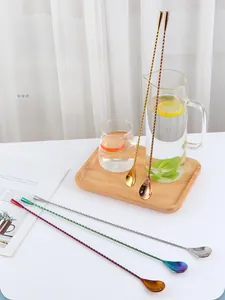 Close-up of spiral handle bar spoons in various plating colors on a wooden tray