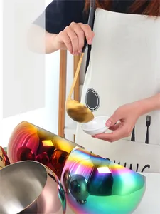 Macro shot of iridescent stainless steel condiment bowl with a golden serving spoon