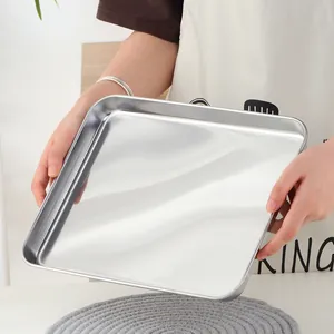 Détail d'un plateau de buffet en acier inoxydable poli avec coins arrondis et finition miroir
