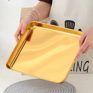 Gros plan d'un plateau rectangulaire en acier inoxydable doré à finition miroir