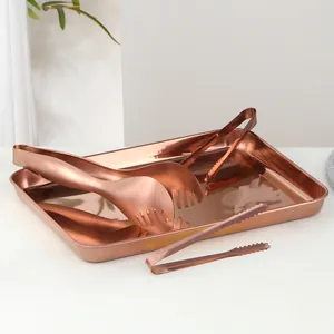 Plateau en acier inoxydable or rose poli avec trois pinces de service pour buffet chic