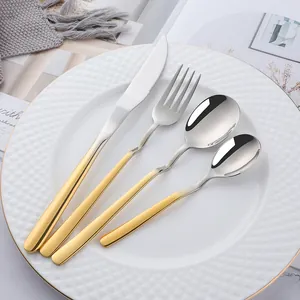 Detailed close-up of premium two-tone silver and gold stainless steel cutlery set on plate