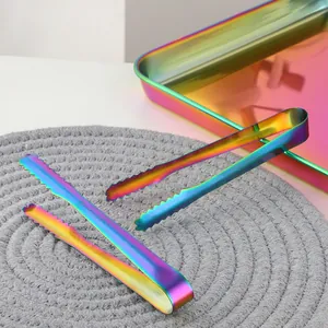 Pinces de service arc-en-ciel en acier inoxydable sur un plateau en métal assorti