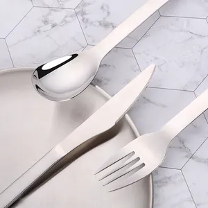 Vue détaillée d'un ensemble de couverts en inox poli avec cuillère miroir et manche mat