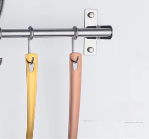 Detail of stainless steel potato masher handles with hanging holes in gold and rose gold