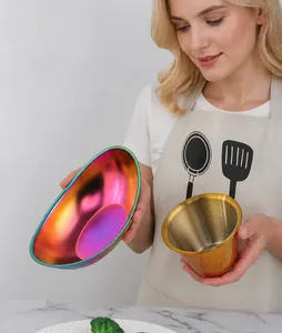 Macro shot of colorful iridescent stainless steel bowl and golden brushed dip cup