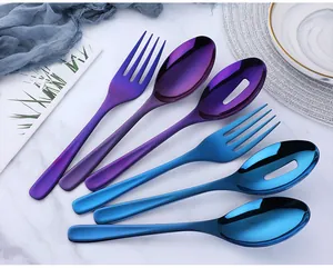 Close-up of titanium plated stainless steel serving spoons and forks on marble background