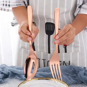 Polished rose gold stainless steel serving set with a large slotted spoon and fork