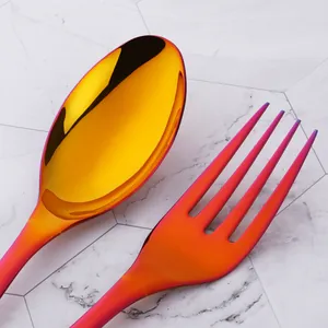 Rainbow titanium stainless steel large serving spoon and fork set on marble background