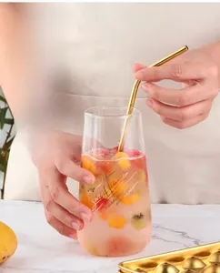 Macro detail of golden 304 stainless steel spherical ice mold with lid and straw