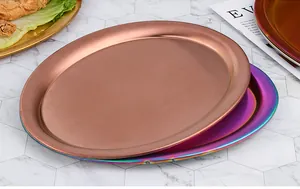 Nahaufnahme von ovalen Edelstahltabletts in Roségold und Regenbogen auf Marmor