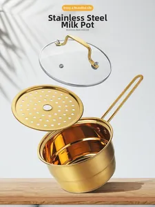 Close-up of golden stainless steel milk pot with steamer tray and glass lid