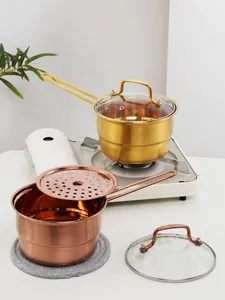 Polished stainless steel milk pans in gold and rose gold with glass lids and steamer inserts