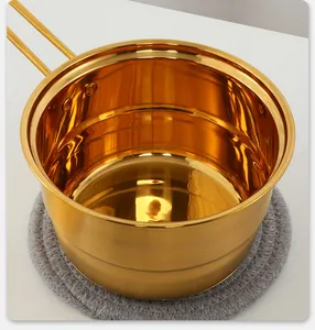 Close-up of polished gold stainless steel saucepan with durable riveted metal handles