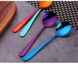 Set of four colorful 304 stainless steel spoons with mirror finish on wooden tray
