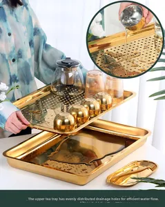 Detail of golden stainless steel double-layer tea tray with drainage holes and water reservoir