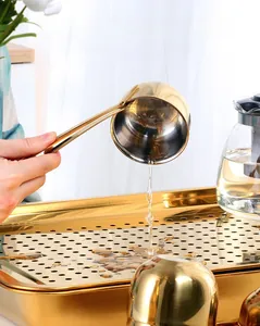 Detail view of golden stainless steel tea tray with polished surface and water drainage holes