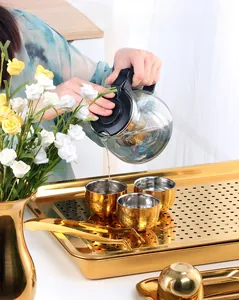 Close-up of pouring tea onto a golden stainless steel tray with drainage holes