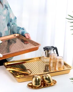 Close-up of golden rectangular stainless steel tea tray with a dual-layer drainage system