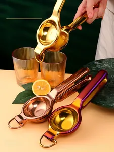 Manual lemon juicers in gold and rose gold finish shown with citrus on kitchen counter