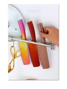 Three colorful stainless steel chef knives on a magnetic rack in a modern kitchen