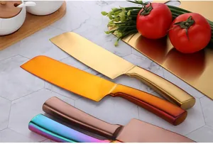Set of colorful stainless steel chef knives in gold, bronze, and rainbow finishes on marble