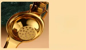Close-up of golden stainless steel lemon squeezer with enlarged capacity and filter holes