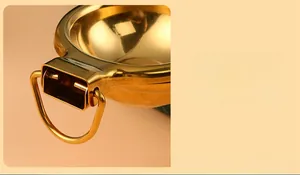 Detail shot of the golden stainless steel lemon squeezer featuring a sturdy hanging ring