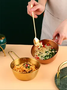 Golden and copper stainless steel ramen bowls with handles and a long gold spoon