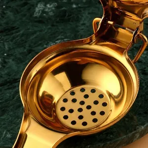 Golden stainless steel manual lemon squeezer with hinged lever and round filter holes