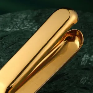 Manual stainless steel lemon squeezer with golden mirror finish and hanging loop tool