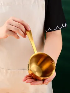 Close-up of golden stainless steel mini pot with double pour spouts and ergonomic long handle