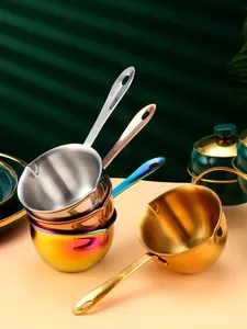Close-up of stainless steel mini butter warmers with dual spouts and long hanging handles