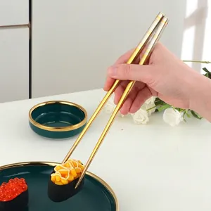 Baguettes en acier inoxydable 316L bicolores or et argent saisissant un sushi frais