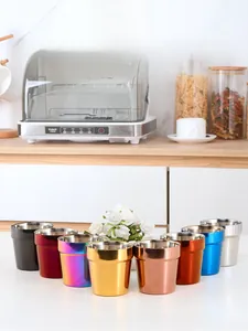 Detail view of 8 colorful double-walled stainless steel cups in a kitchen setting